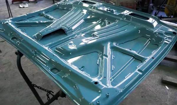 メタリックな光沢のあるブルーの自動車ボンネットの裏面