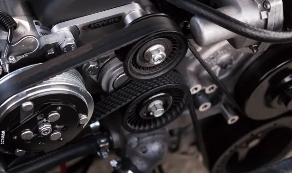 自動車エンジンのプーリーとベルト周りの機構を接写した写真