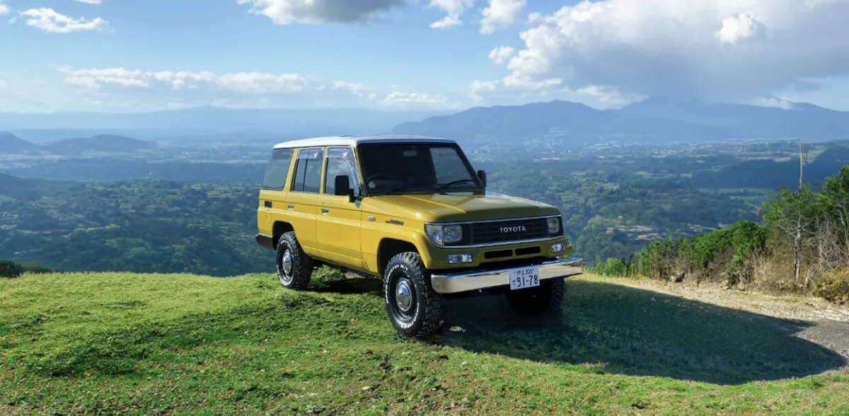 山の絶景を背景に停車する黄色のトヨタSUVと広がる自然風景