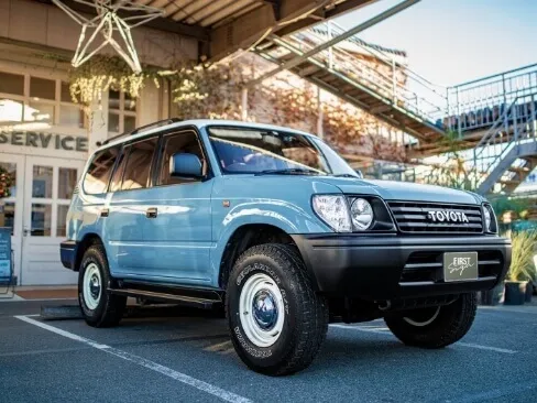 商業施設前に停車している水色のトヨタSUVの斜め前方写真